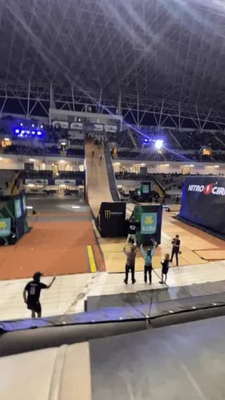 BMX riders launching off a massive indoor mega ramp at Nitro Circus