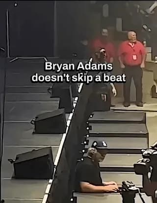 A concert goer jumps on stage and interrupts the show, but Bryan Adams gets right back into the song like it never happened.