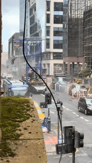 Apartment balcony view of practical stunt rigging and explosions being filmed for Spider-Man