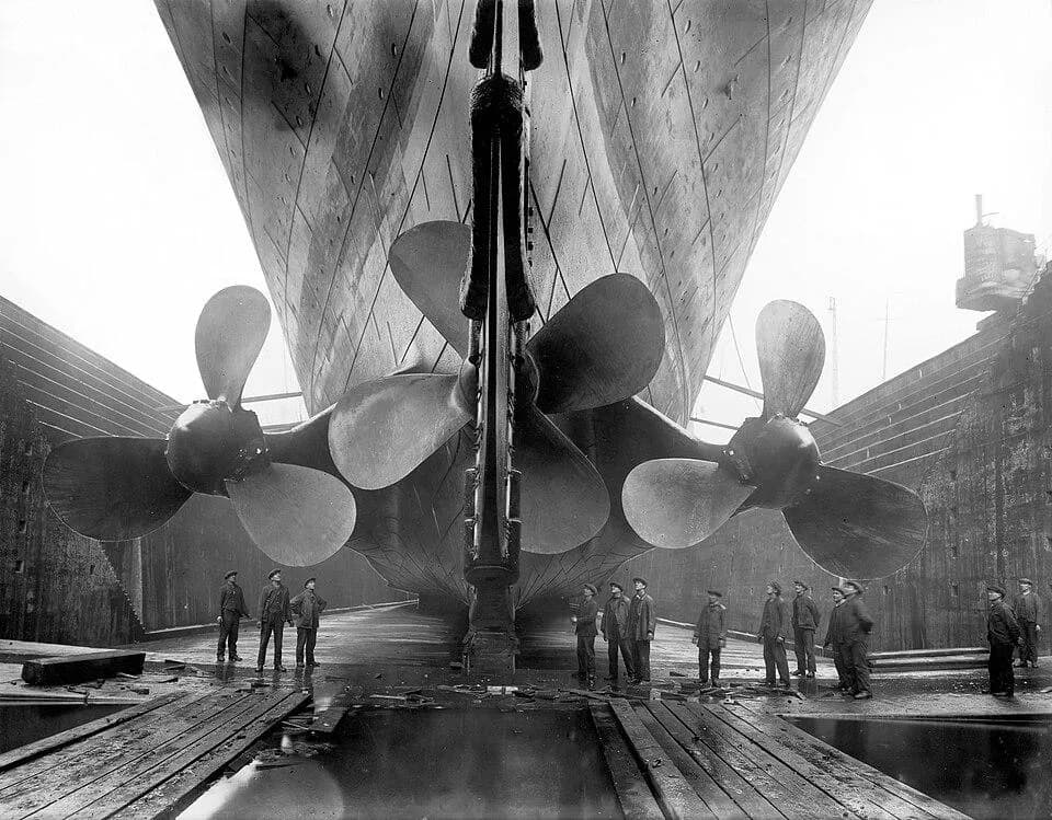 The enormous propellers of RMS Olympic, photographed with shipyard workers for scale in 1924