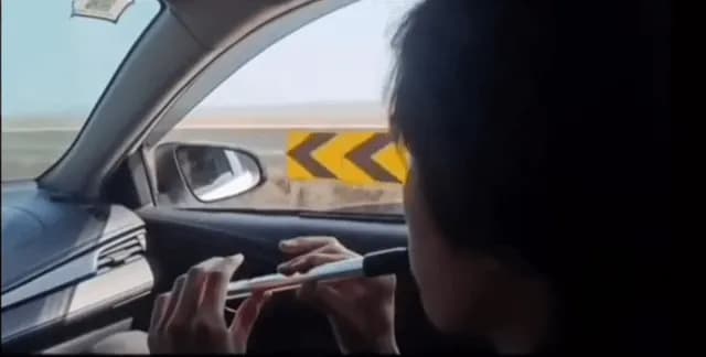 Man plays flute using head wind while in a car