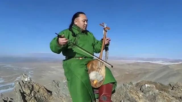 Batzorig Vaanchig, a famous Mongolian Throat Singer, sitting on a mountaintop and singing “Chinggis Khaanii Magtaal” (In Praise of Chinggis/Genghis Khan).