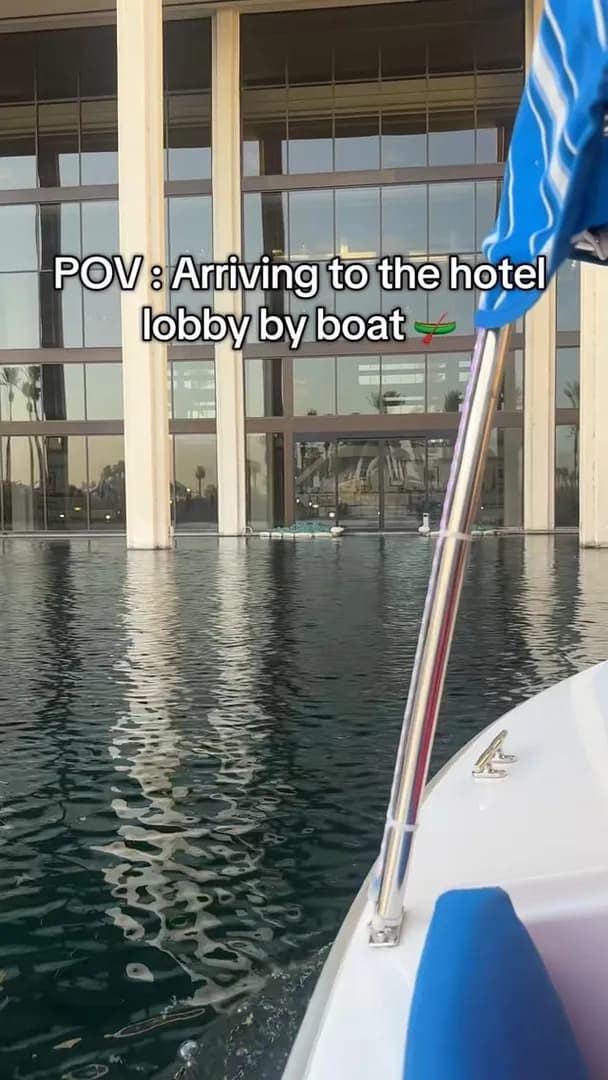 People arriving at the hotel by boat, with water seamlessly integrated into the building’s design