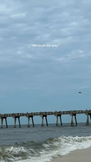 The U.S. Navy Blue Angels' signature tight-formation F/A-18 maneuver stuns beachgoers as a second iet appears below the first during a low-altitude Pensacola flyover, part of the 2026 air show honorin