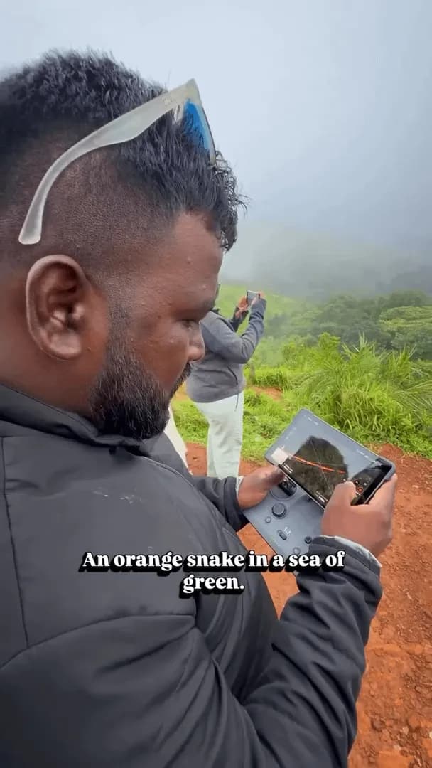 An orange train winding through the Western Ghats looks like a snake moving through a sea of green.
