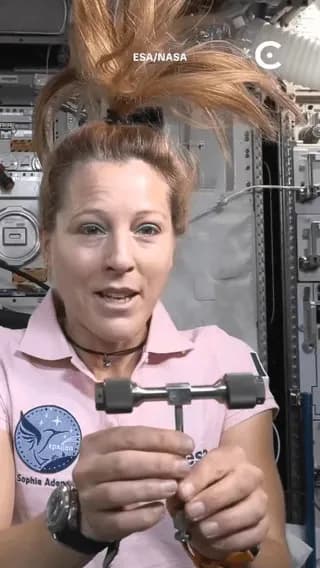 An astronaut demonstrating the Dzhanibekov effect in microgravity, where an asymmetric object spinning around its intermediate axis becomes unstable and periodically flips 180 degrees