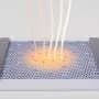 Faint far-infrared radiation drives a correlated insulator-to-metal transition in magic-angle graphene