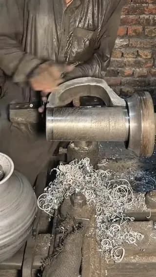 The process of turning and smoothing a cast aluminum cookware pot on a lathe