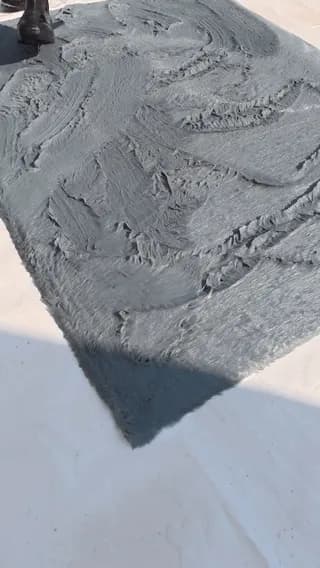 Smoothing out a carpet with a screed