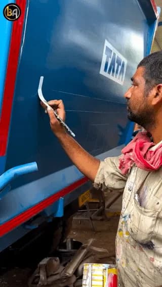 Man with immaculate calligraphy skills writing on the back of the truck