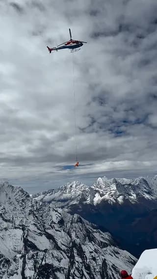 When a helicopter can’t land on a Himalayan mountain, rescuers hang from a cable to reach stranded climbers