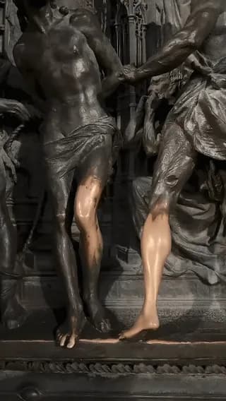 Close-up of the Flagellation scene on the bronze doors of the Duomo di Milano where millions of passing tourists touching the figures for good luck have stripped away the dark patina leaving the bare