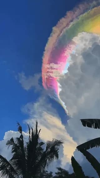 A rare natural phenomenon known as cloud iridescence, where uniform ice crystals diffract sunlight to create a vivid rainbow effect over Jonggol, Indonesia