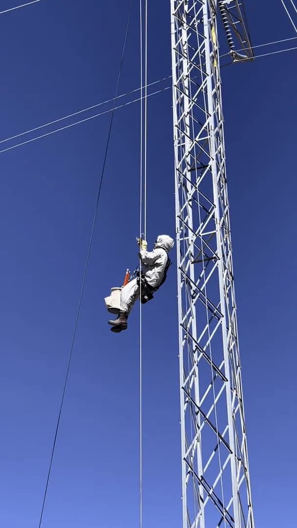 Rope access work on an energized 345,000 volt transmission line.