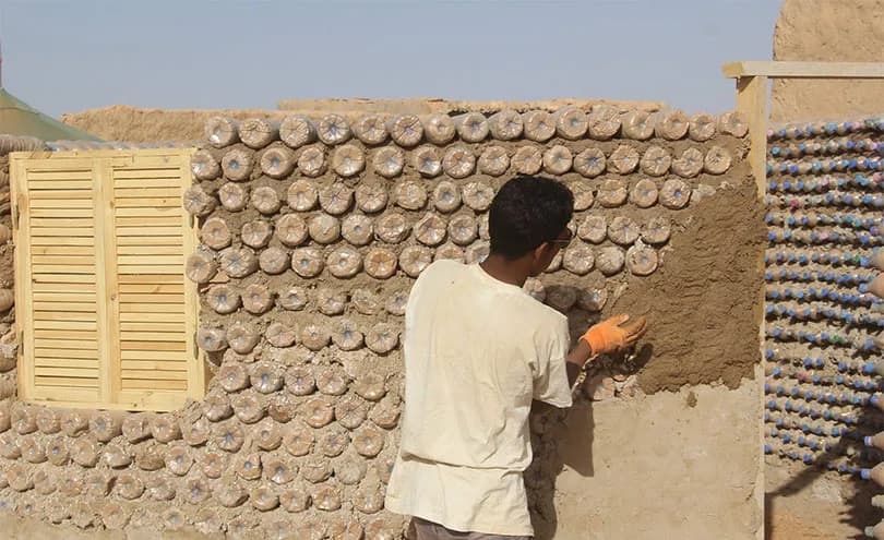 In the Algerian desert, refugee Tateh Lehbib builds circular, flood- and heat-resistant homes using discarded plastic bottles filled with sand instead of traditional mud bricks.
