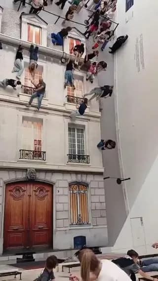 "The Building" by Leandro Erlich, an art installation using a 45 degree giant mirror to make people lying on the ground look like they're dangling from the building.