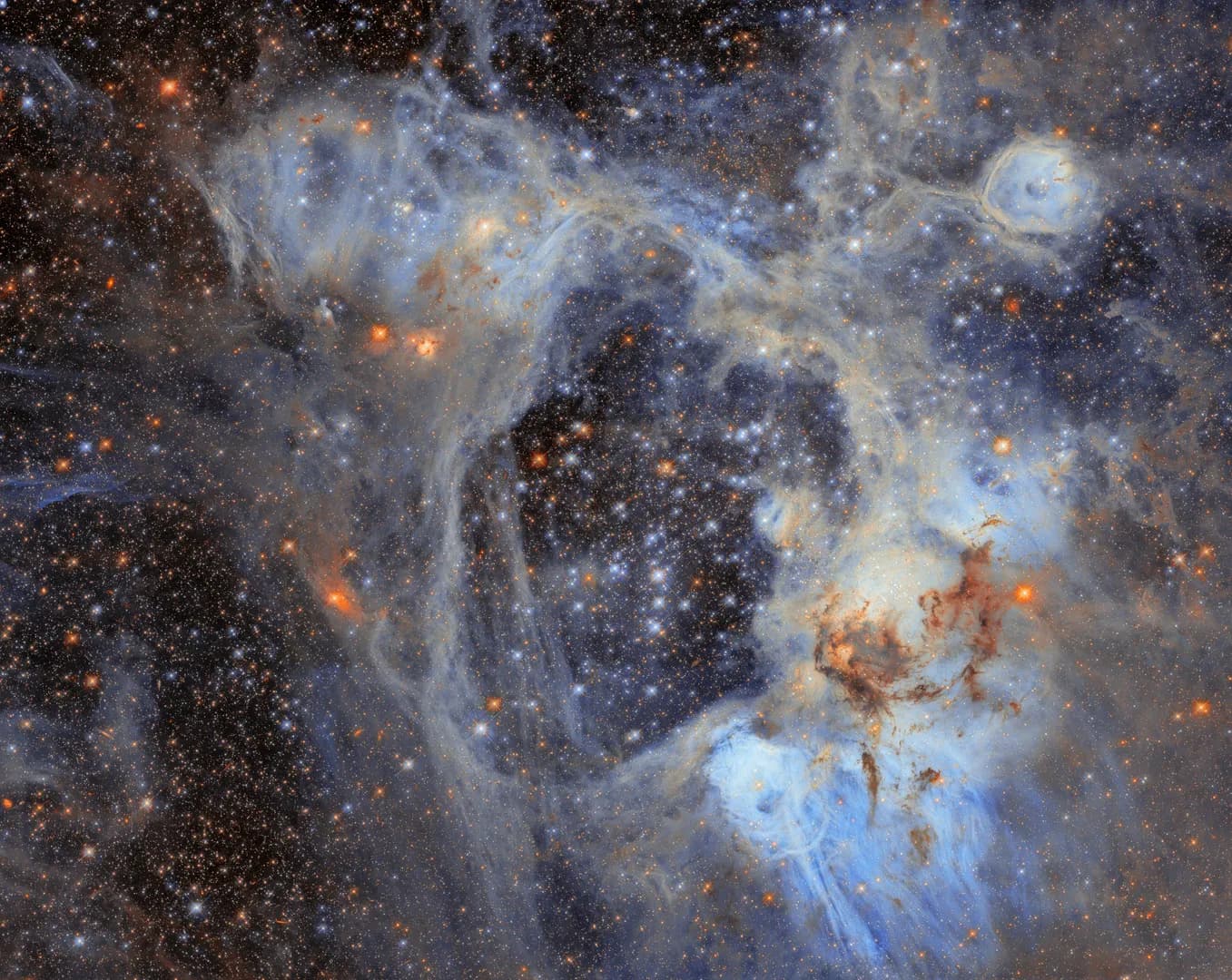 The dark void in this Hubble image is a 210 by 140 light year superbubble carved out by stellar winds and supernovae